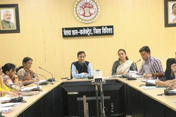कलेक्ट्रेट के सभागार में मेज के चारों ओर बैठे अधिकारी समीक्षा बैठक करते हुए